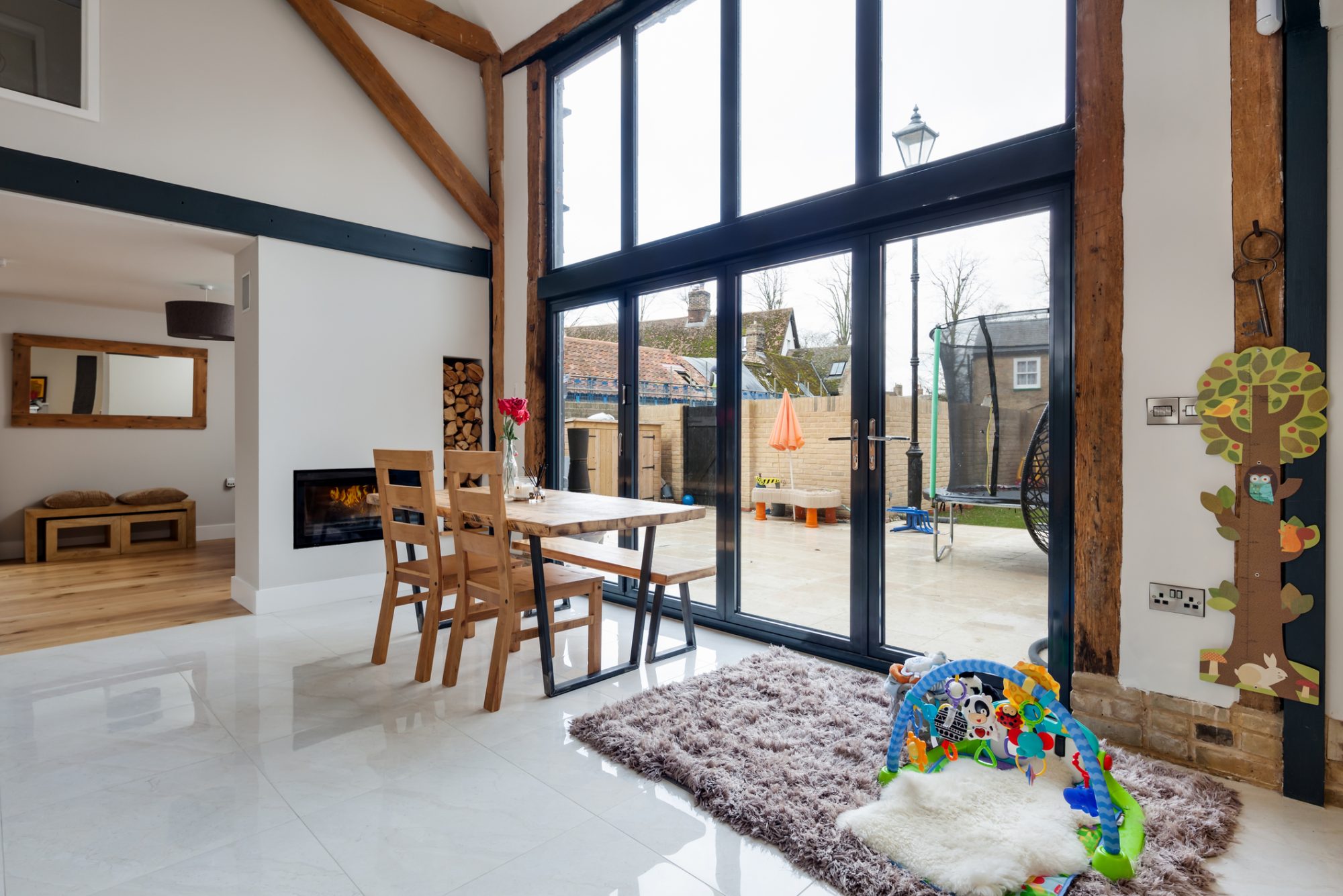 Cottenham, Cambridgeshire, England - Jan 23 2018: Open plan family dining hall with bifold doors in modern renovated barn